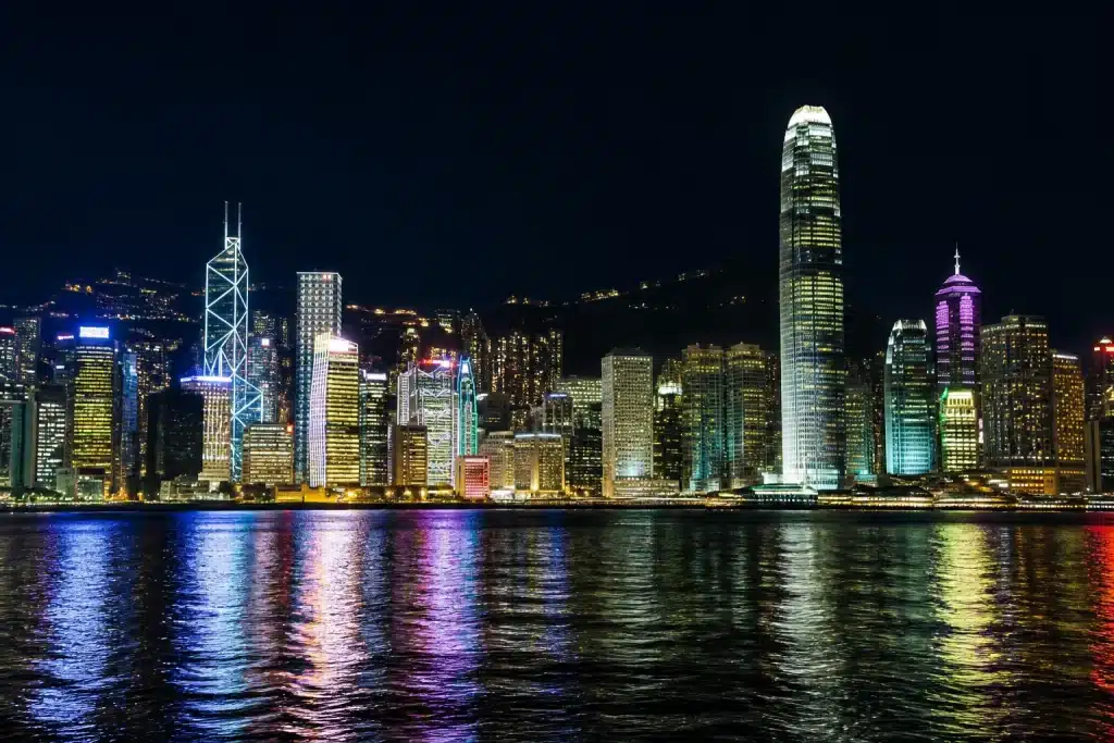 Skyline notturno di Hong Kong con grattacieli illuminati riflessi