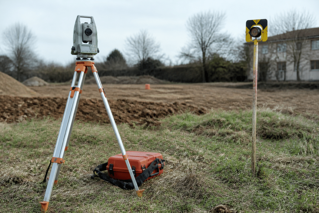 Terreno con strumenti di misurazione e cartello prezzi urbanizzazione