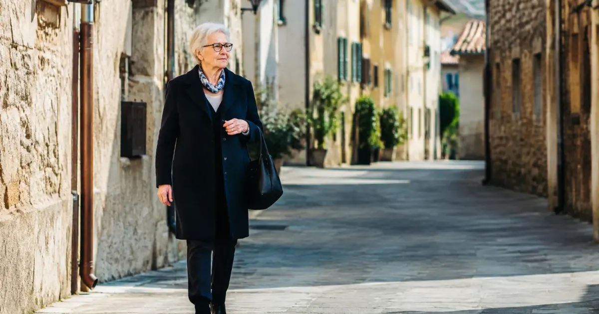 Donna anziana cammina sola per strada vuota