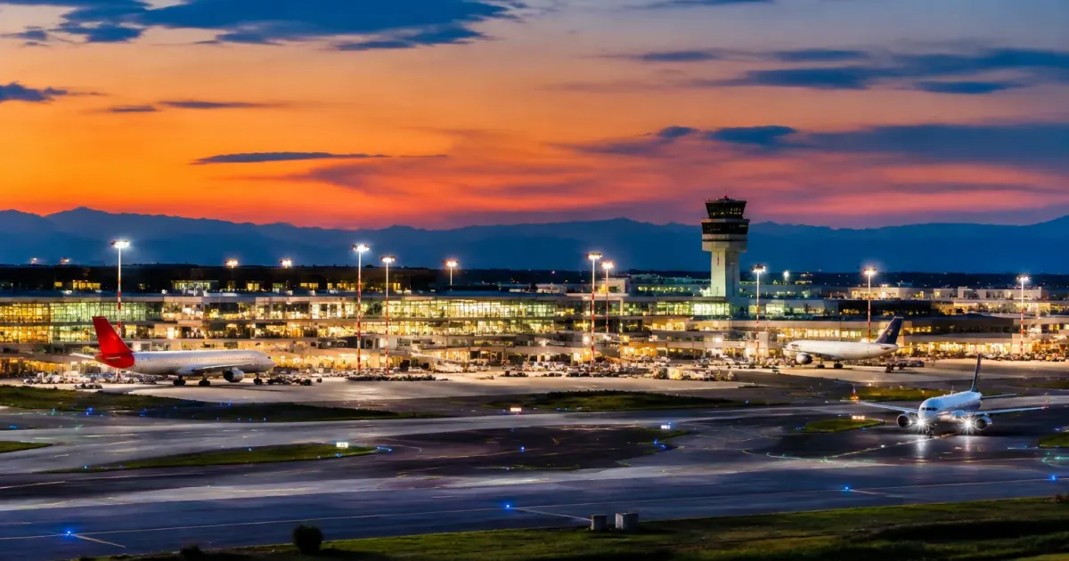 Aeroporto Malpensa con edifici terminale e piste di decollo illuminate