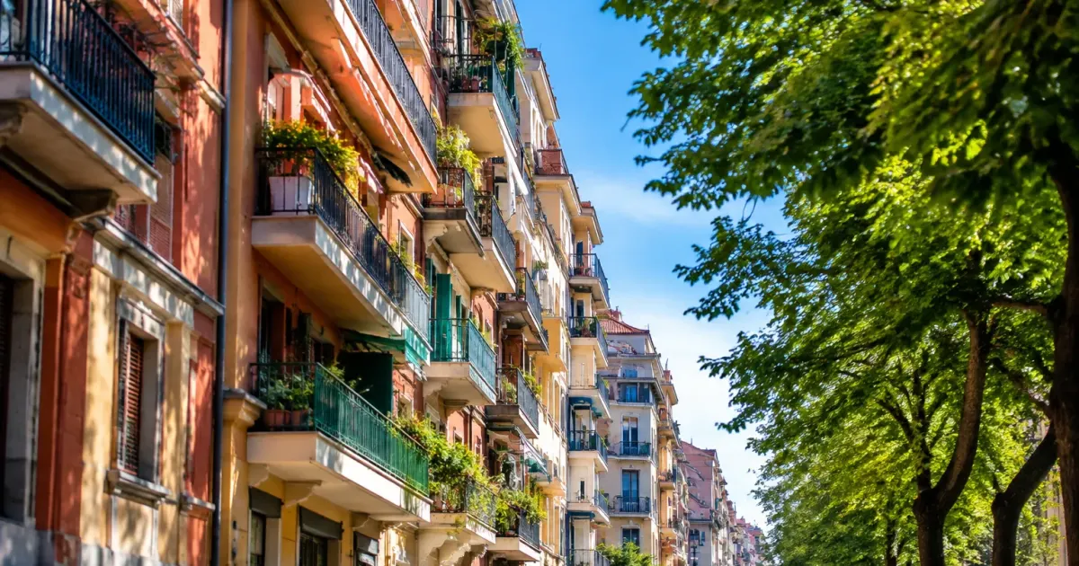Palazzi residenziali allineati verticalmente con balconi lungo viale urbano