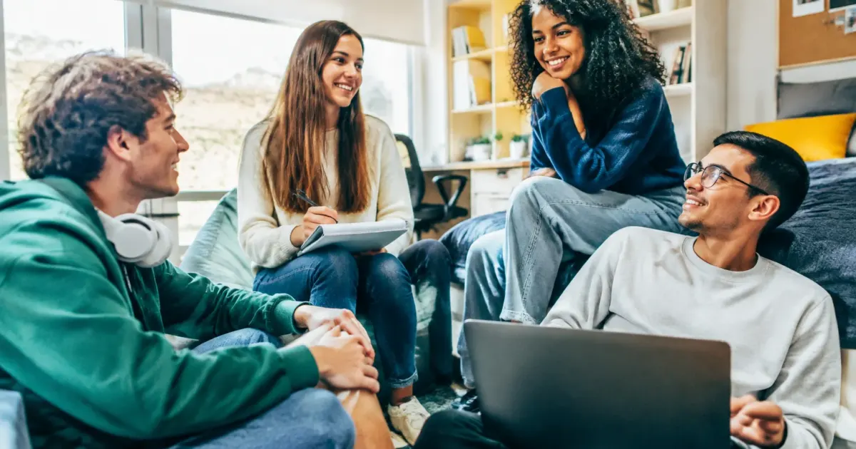 Studenti seduti insieme in moderna residenza universitaria luminosa