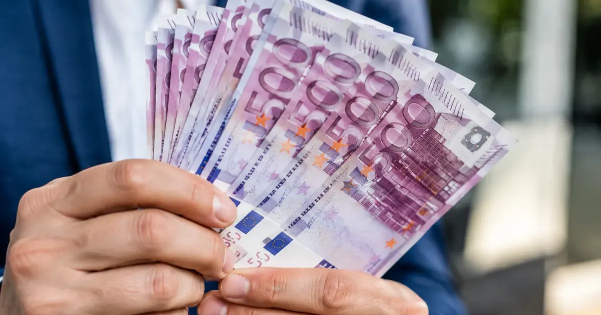 Mani che tengono banconote da cinquecento euro in primo piano